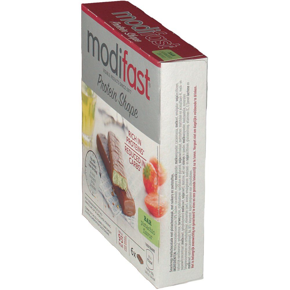 Schrägansicht der Modifast Proti Plus Barre Pistache Verpackung. Aufdrucke: Protein Shape, Pistaziengeschmack, reich an Proteinen, reduziert an Kohlenhydraten.