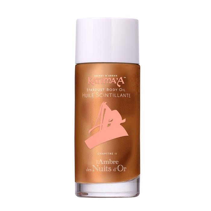 Flacon d'huile pour le corps avec bouchon blanc. Inscription : Katima'a, Stardust Body Oil, Huile Scintillante. Fond doré avec graphique rose.