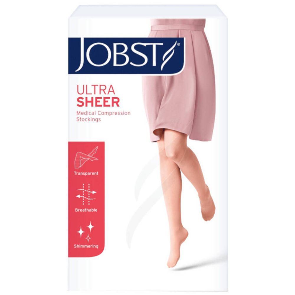 Emballage de JOBST Ultrasheer Kniestrumpf. Une jambe portant un bas est représentée. Texte : Transparent, respirant, scintillant.