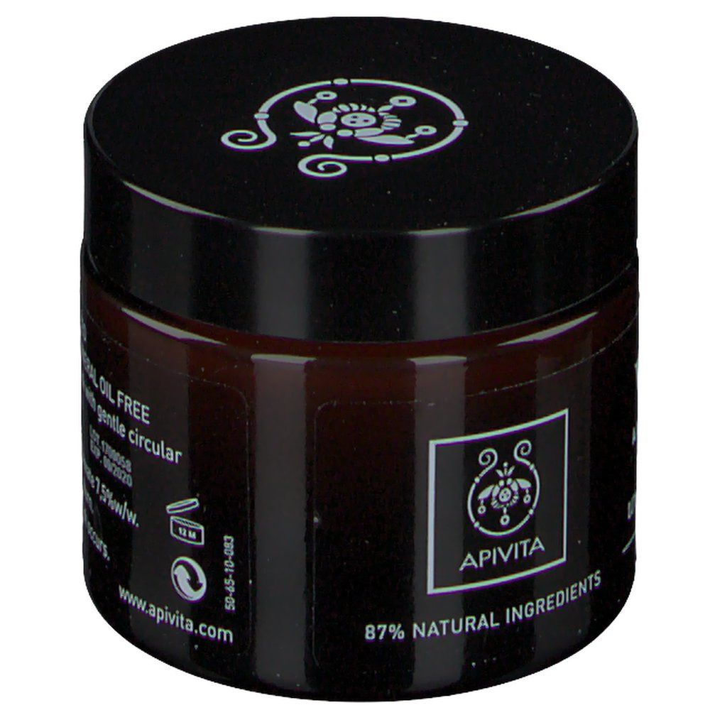 Crème brune en pot de verre avec couvercle noir. Inscription : Apivita, 87% Natural Ingredients. Logo.