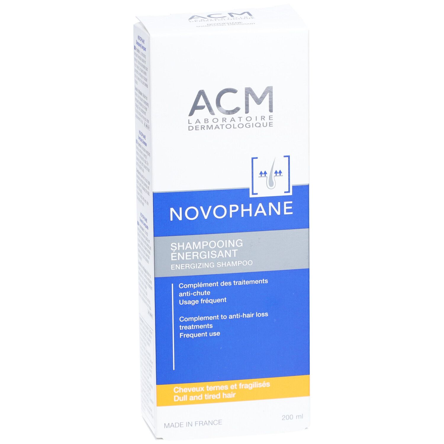Boîte blanche avec texte bleu et gris. Inscription: ACM, Novophane, Shampooing Énergisant. Emballage du produit.