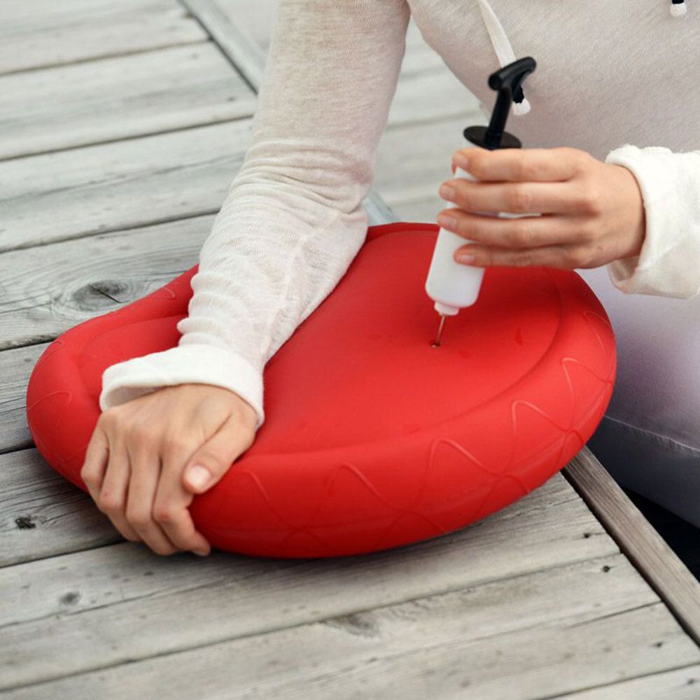 Persoon gebruikt pomp met rood kussen. Pomp wordt in kussen gestoken.