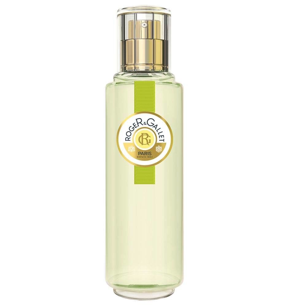 Flacon cylindrique en verre avec vaporisateur doré. Étiquette avec logo et texte. Liquide vert clair visible.