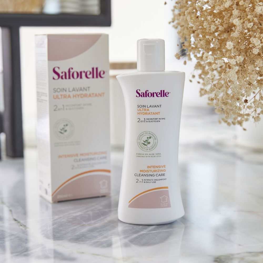Witte fles en doos. Opschrift: Saforelle, Soin Lavant Ultra Hydratant. Op marmeren oppervlak.