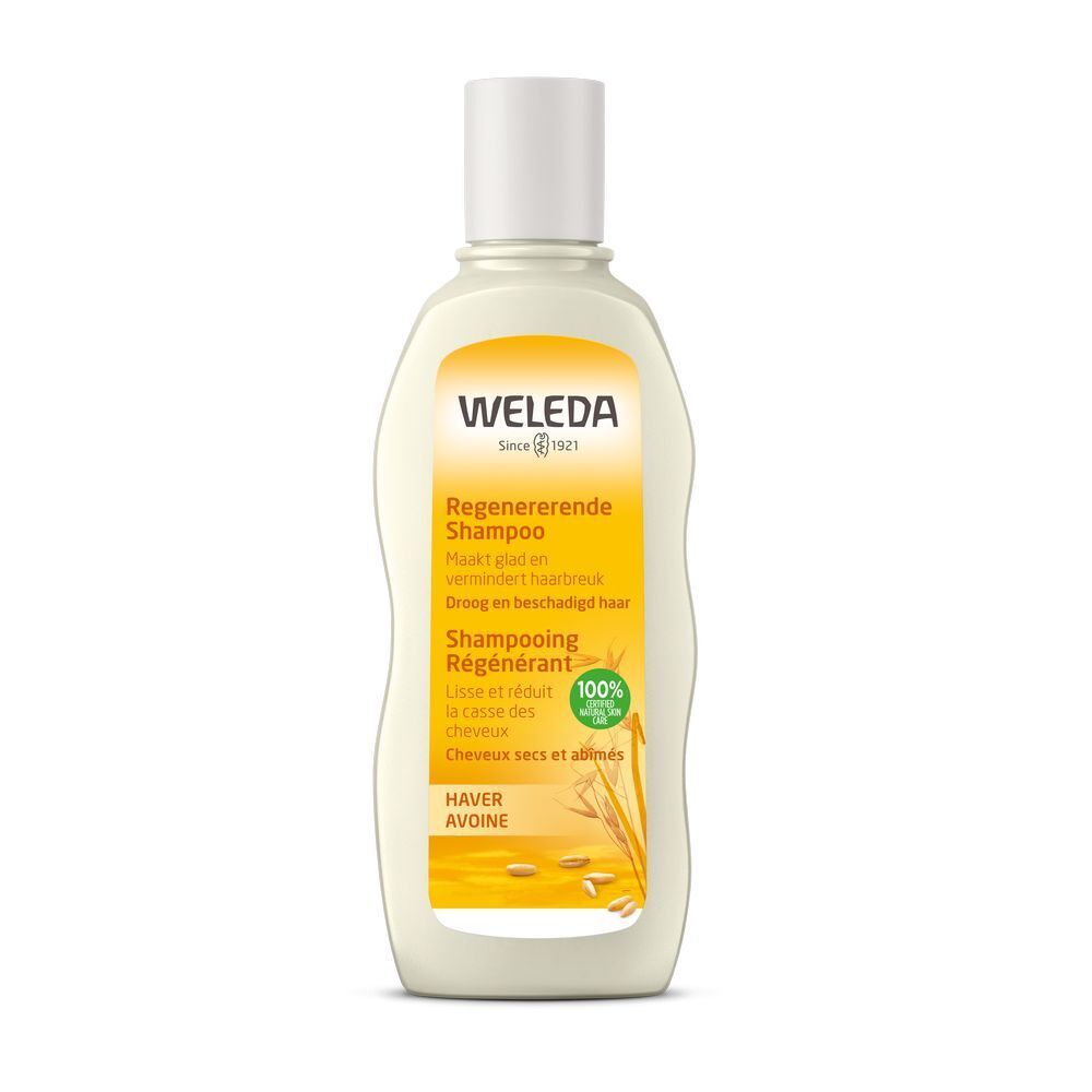 Flacon de shampooing Weleda. Récipient blanc avec étiquette jaune. Texte: Shampooing Régénérant, Avoine. Sceau vert.