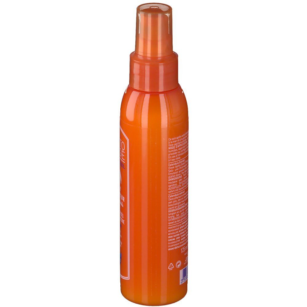Orangefarbene Sprühflasche. Seitliche Ansicht. Aufschrift nicht lesbar. Transparente Kappe.