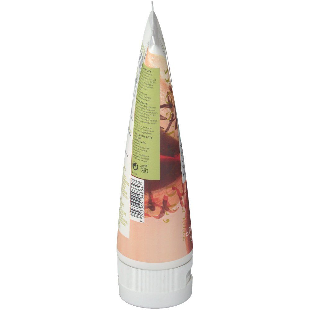 Tube de lait corporel, bouchon blanc. Vue latérale avec étiquette montrant partiellement le nom du produit et des illustrations.