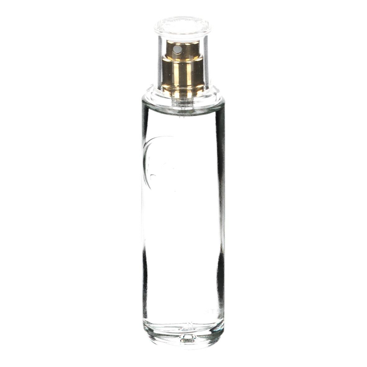 Transparante glazen fles met gouden verstuiver. Bevat heldere vloeistof. Cilindrische vorm.