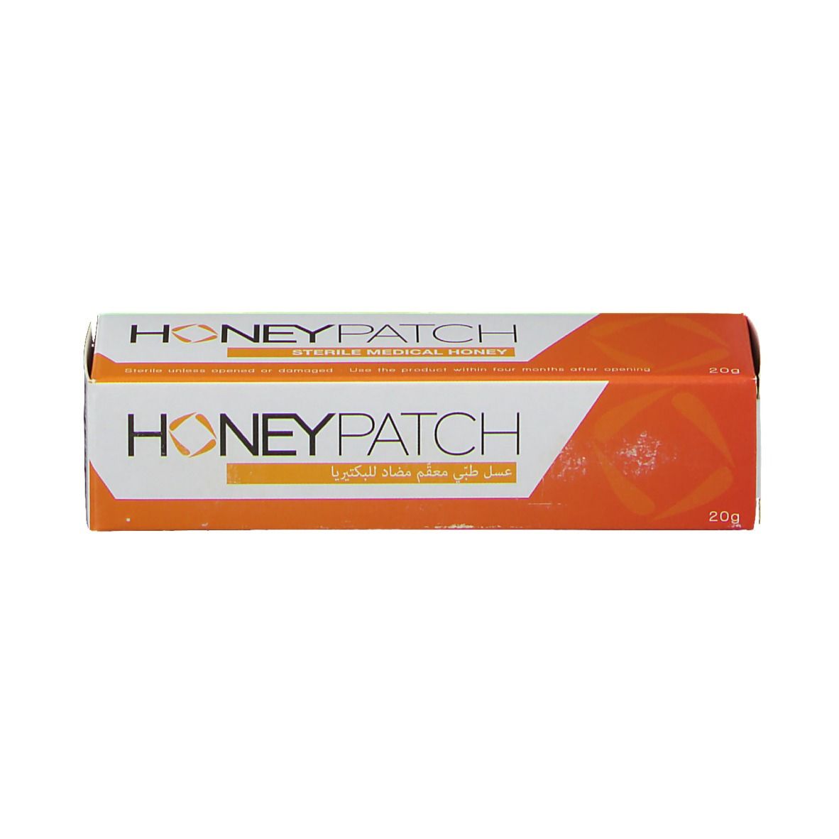 Verpakking honing. Wit-oranje ontwerp. Opschrift: Honeypatch. 20g. Steriele medische honing. Arabisch schrift.