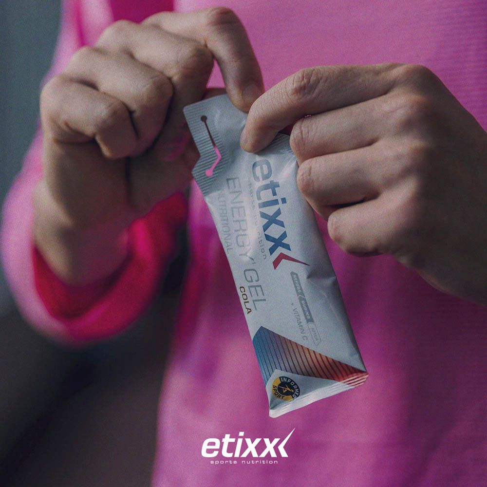 Handen openen Etixx Energy Gel Cola. Logo en tekst. Sport Banned Tested.