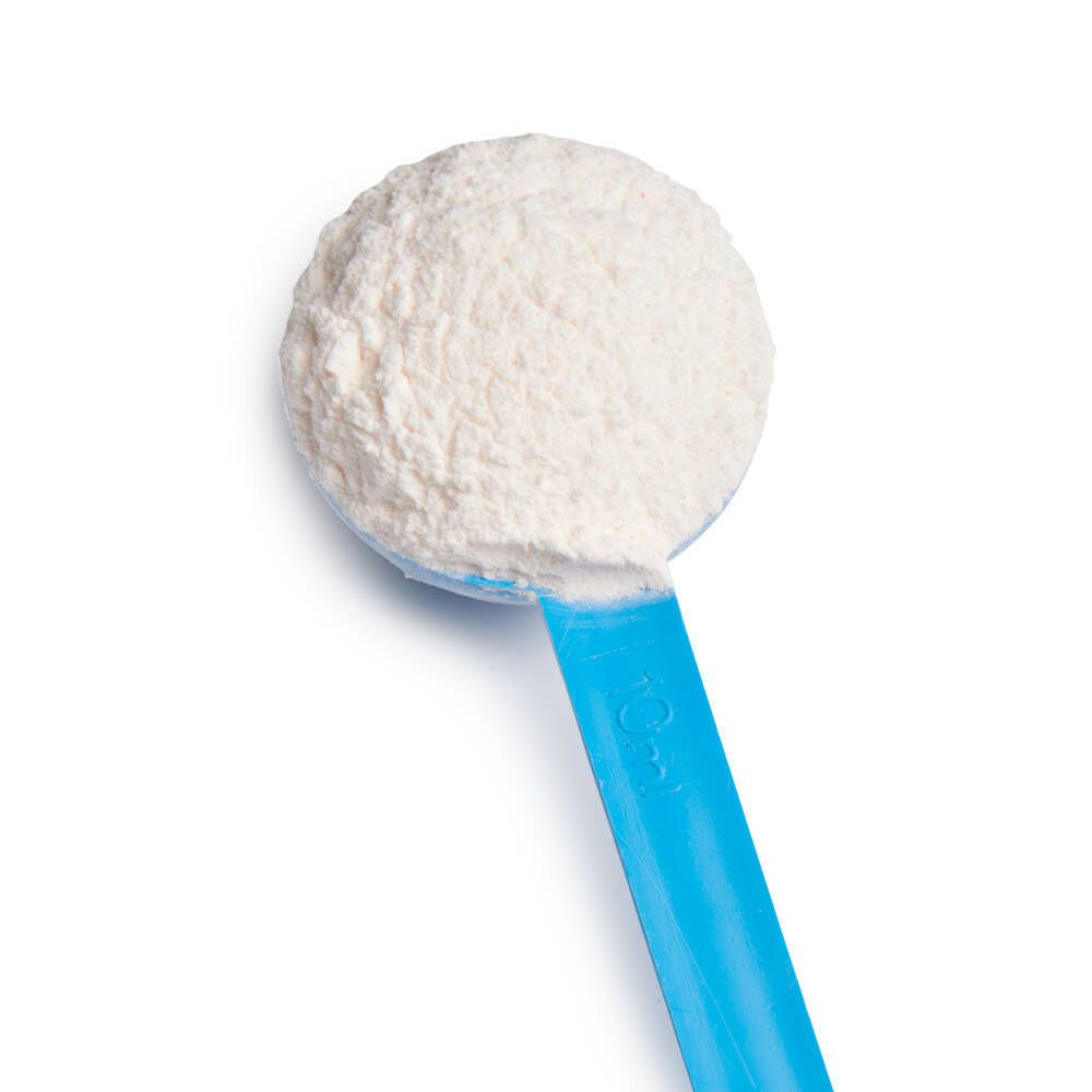 Cuillère bleue avec poudre blanche. Gros plan.