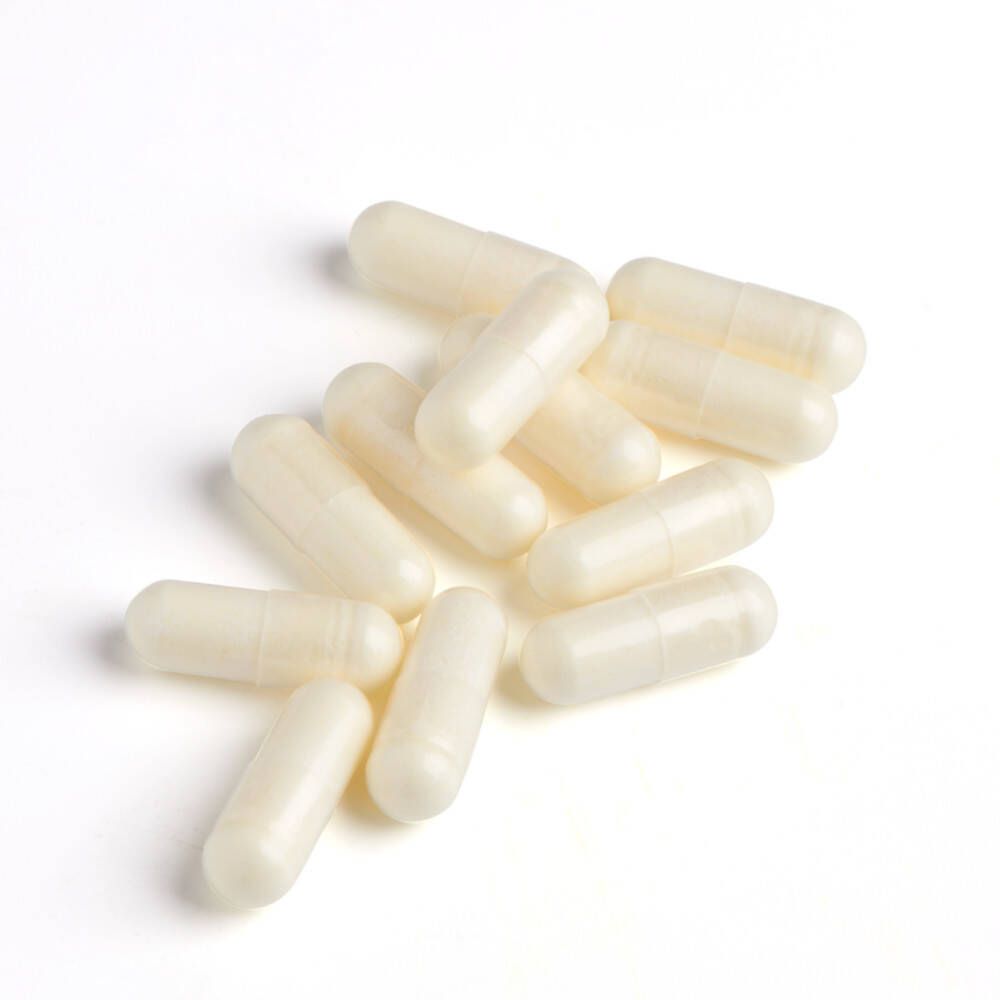 Dix capsules ovales, crème, sur fond blanc.