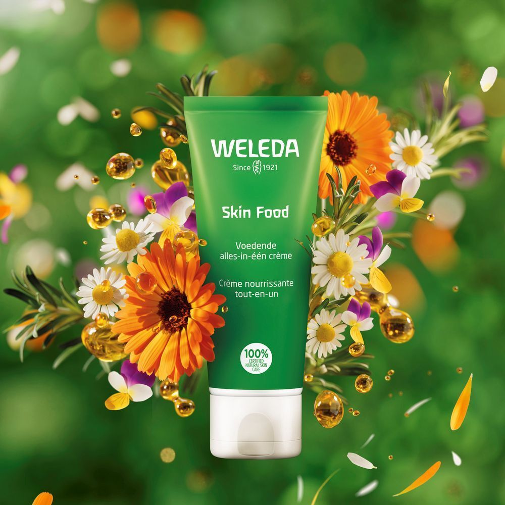 Tube vert Skin Food entouré de fleurs et gouttes d'huile. Inscription: WELEDA. Label: 100% cosmétiques naturels certifiés.