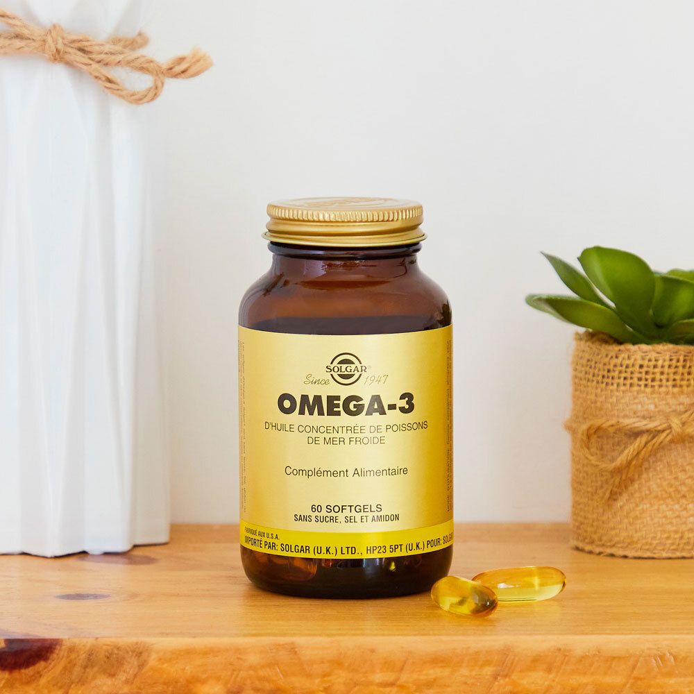 Braune Flasche mit goldenem Deckel. Aufschrift Omega-3. Neben Dekoration.