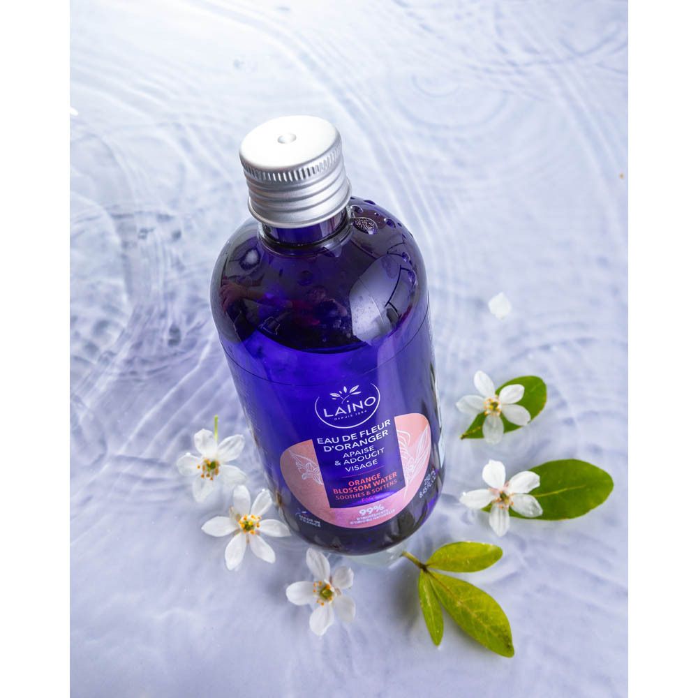 Produit dans l'eau. Flacon bleu avec bouchon argenté. Inscription: LAINO, Eau de Fleur d'Oranger, Apaise & Adoucit Visage.