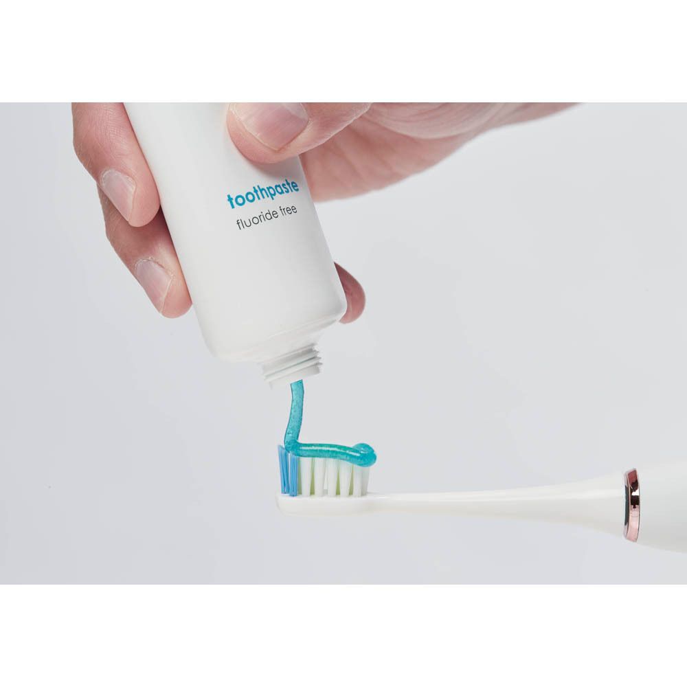 Tube de dentifrice. Le dentifrice est pressé sur une brosse à dents. Dentifrice bleu.