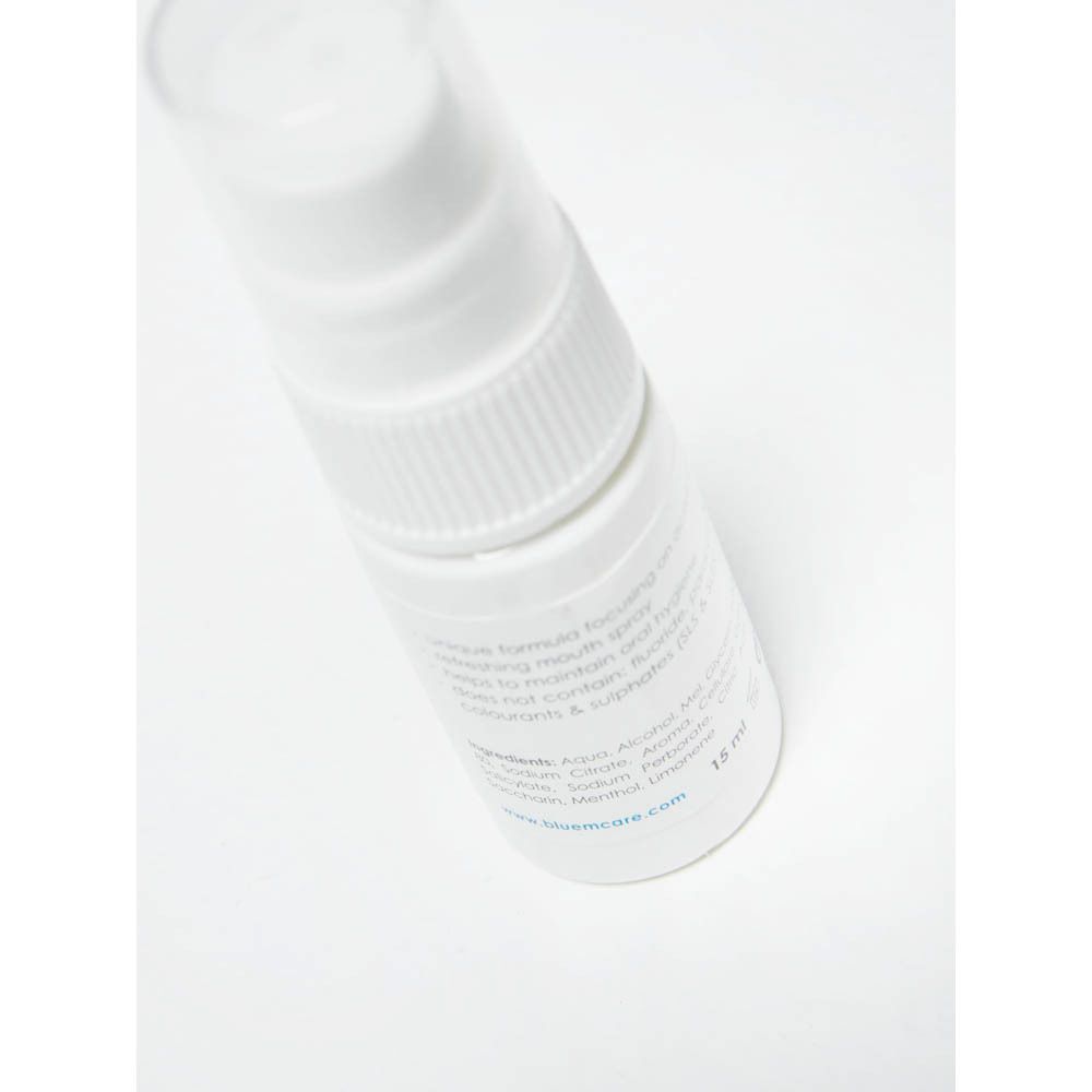Gros plan du spray buccal blanc avec tête de pulvérisation. Inscription : bluem, mouth spray, instant fresh.