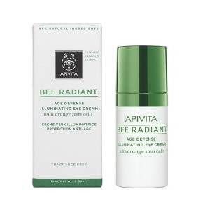 Tube de crème pour les yeux blanc avec bouchon vert à côté de l'emballage. Inscription: Apivita, Bee Radiant, crème contour des yeux anti-âge.