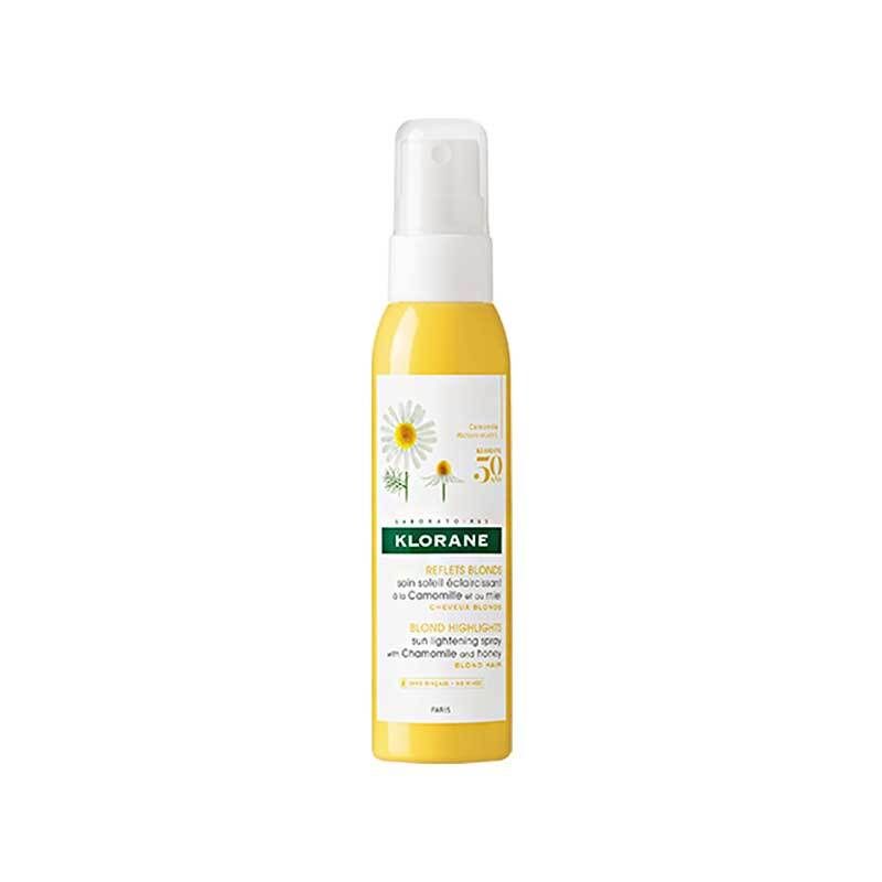 Flacon jaune avec vaporisateur blanc. Inscription: Klorane, Reflets Blond, spray éclaircissant au soleil à la camomille et au miel.