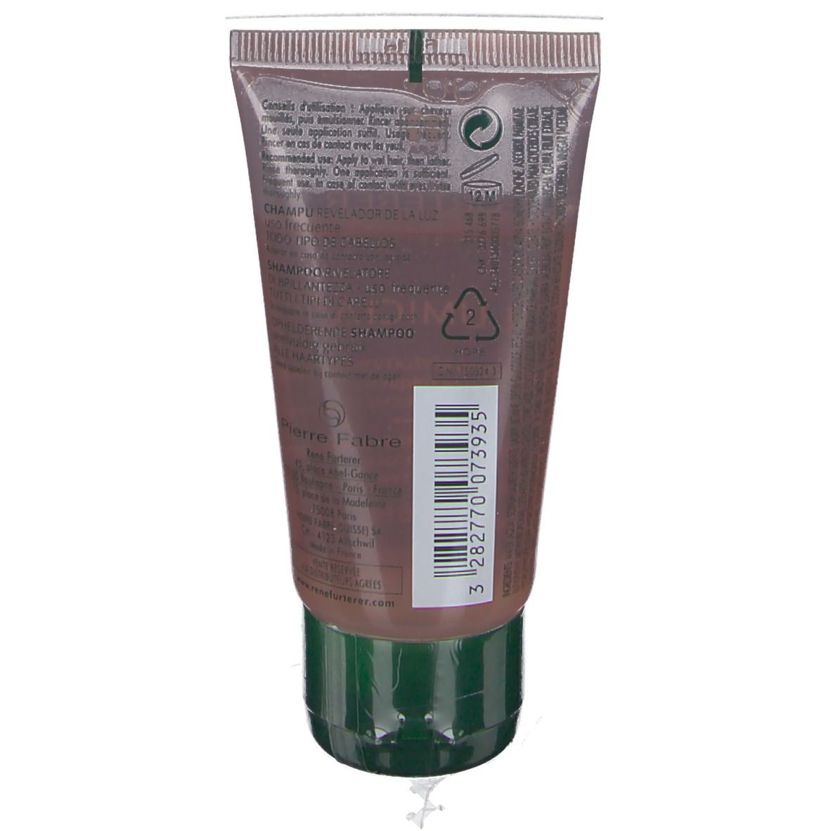Achterkant van de shampoo tube. Tekst en barcode. Groene dop. Transparante tube met bruine shampoo.