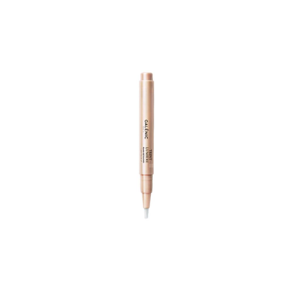 Stylo beige. Inscription GALÉNIC TEINT LUMIÈRE. Pointe avec liquide blanc. Sur fond blanc.