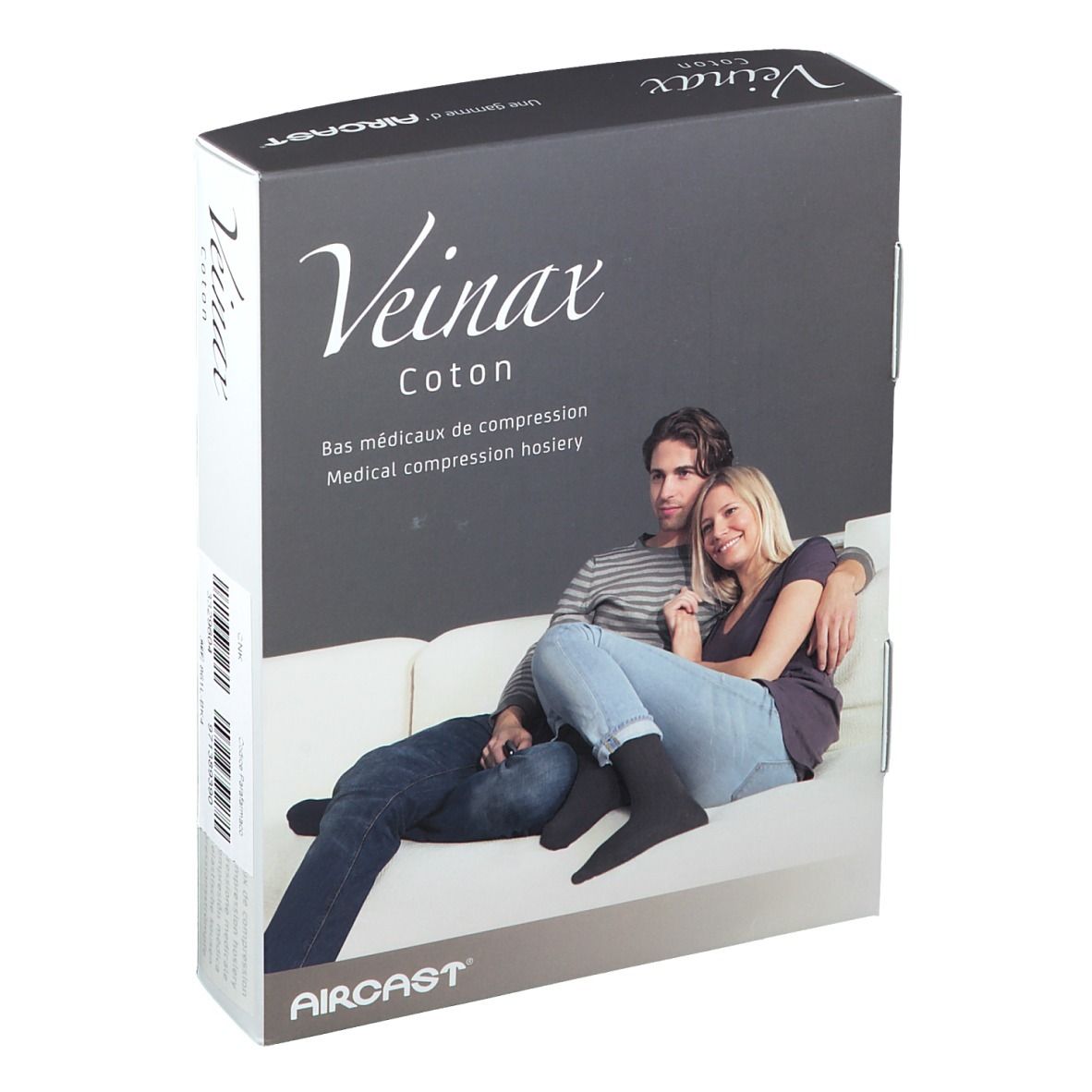 Boîte de bas de compression médicaux. Inscription: Veinax Coton. Couple sur un canapé. Bas noirs visibles.