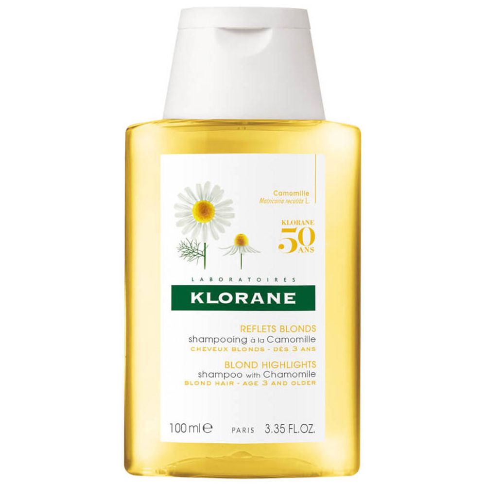 Klorane Shampooing À La Camomille fles. Gele fles met witte dop. Etiket met kamillebloemen en tekst. "Reflets Blonds" en "Blond Highlights".