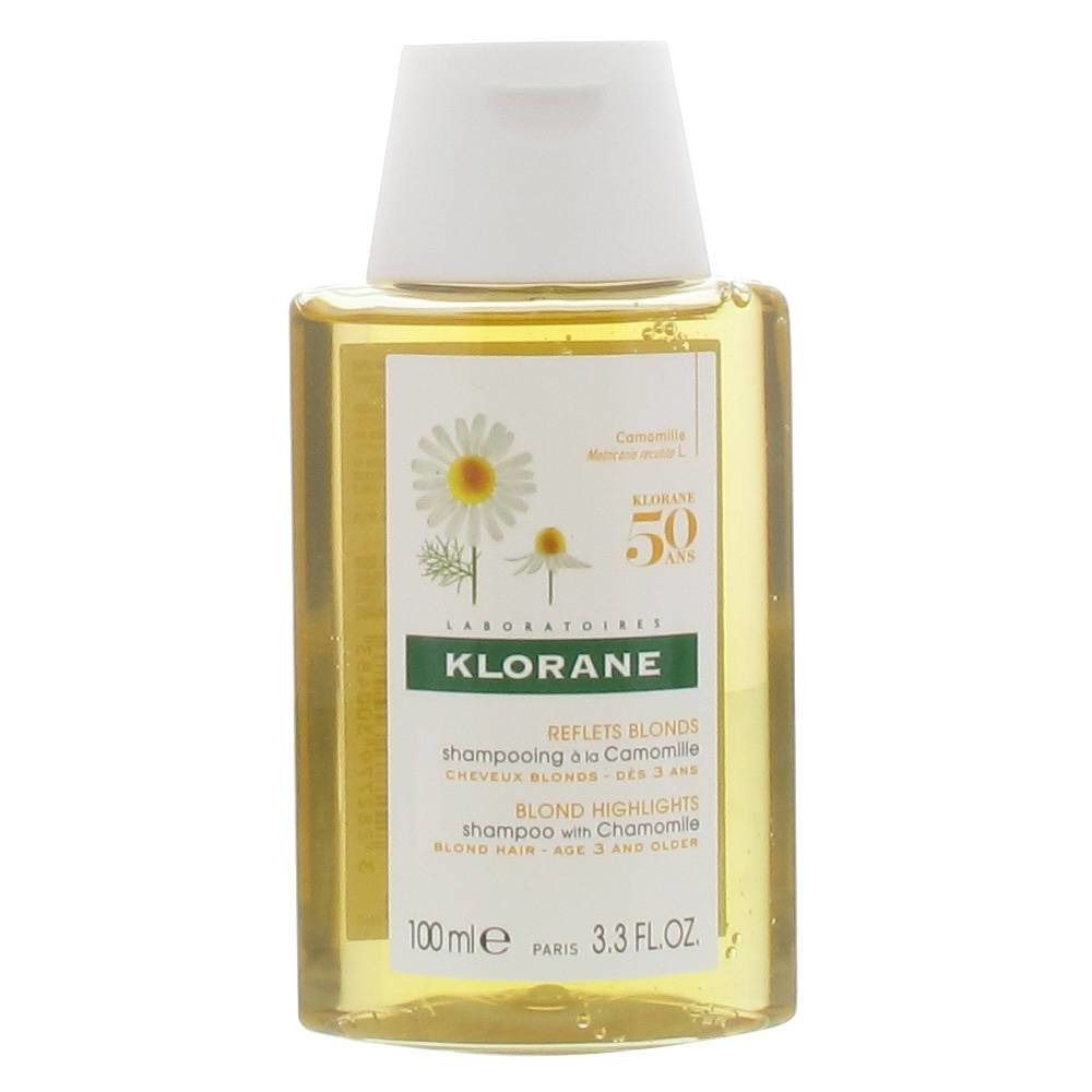 Klorane Shampooing À La Camomille fles. Gele fles met witte dop. Etiket met kamillebloemen en tekst. "Reflets Blonds" en "Blond Highlights".