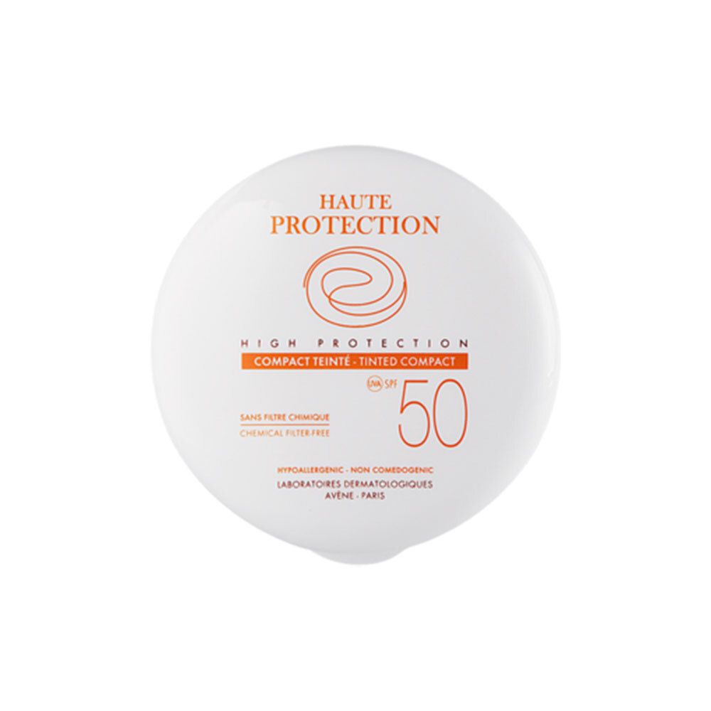 Ronde, witte compacte zonnecrème. Oranje tekst: HAUTE PROTECTION, SPF 50, COMPACT TEINTE.