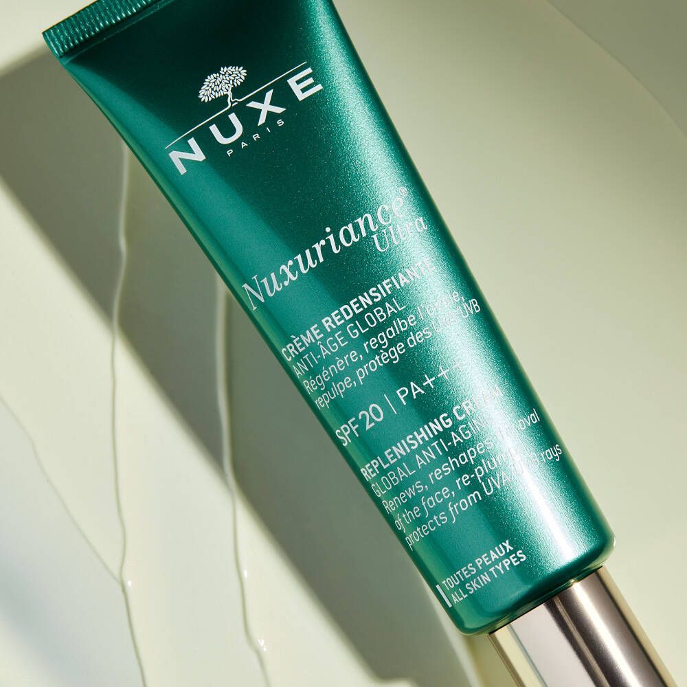 Gros plan sur un tube vert. Inscription: NUXE, Nuxuriance Ultra, Crème-Fluid. Avec SPF 20. Texte en français et anglais.