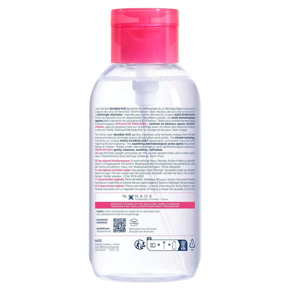 Transparante fles met pomp. Achterkant met tekst. Rode dop. Label met productinformatie. QR-code en pictogrammen.