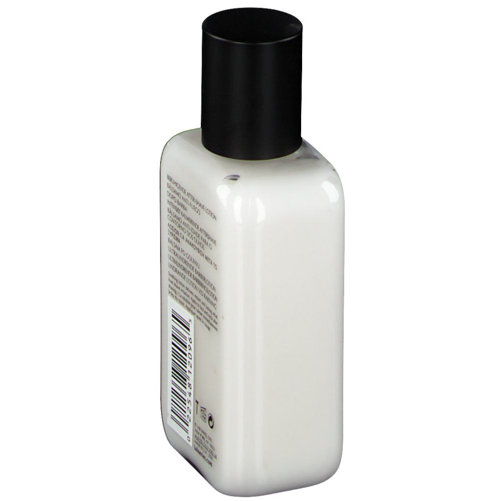 Witte fles, zwarte dop. Achterkant met tekst en barcode. Benaming: Verzachtende aftershave lotion.