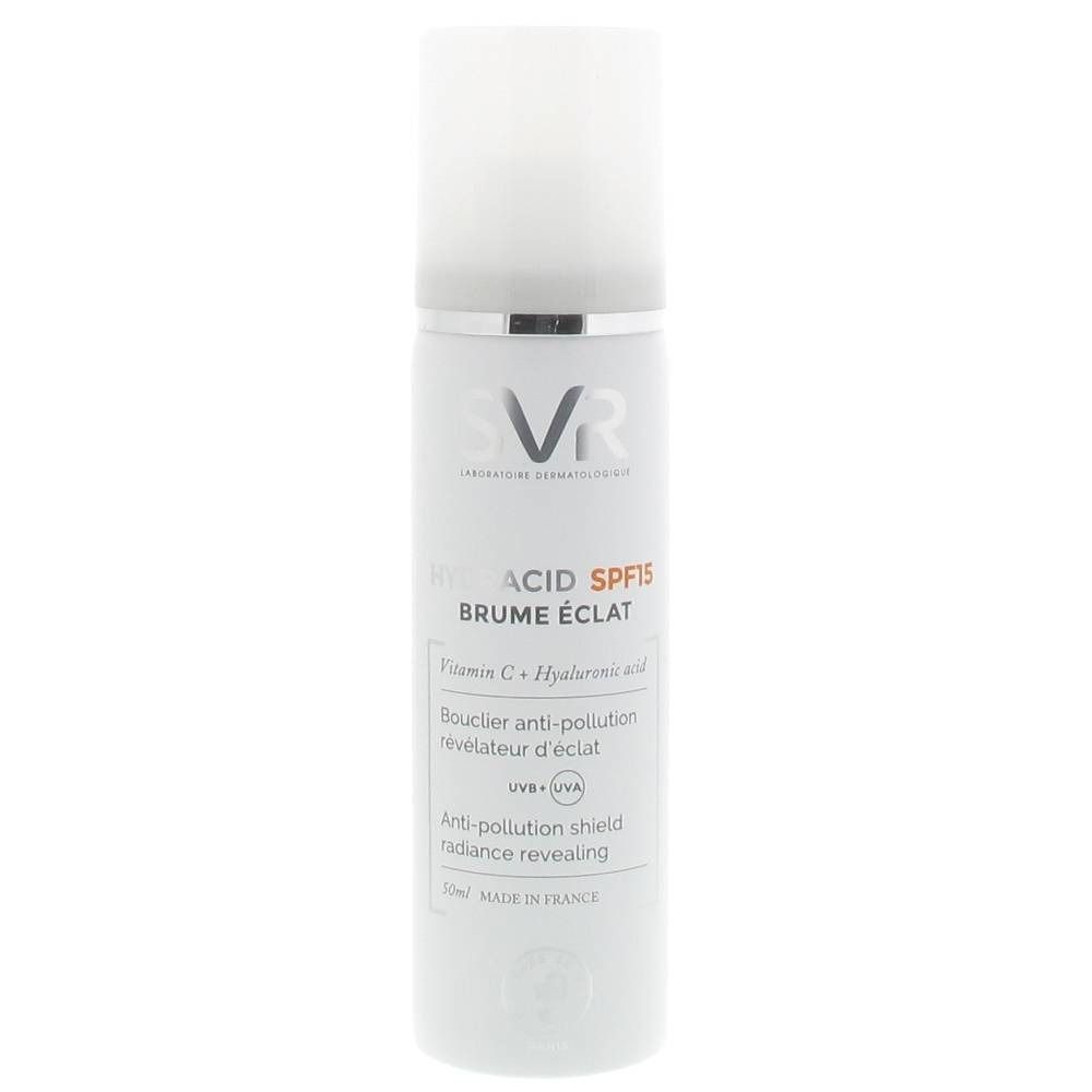 Spray blanc avec bague argentée et bouchon blanc. Inscriptions: SVR, ACID SPF15, BRUME ÉCLAT. Contient vitamine C et acide hyaluronique.