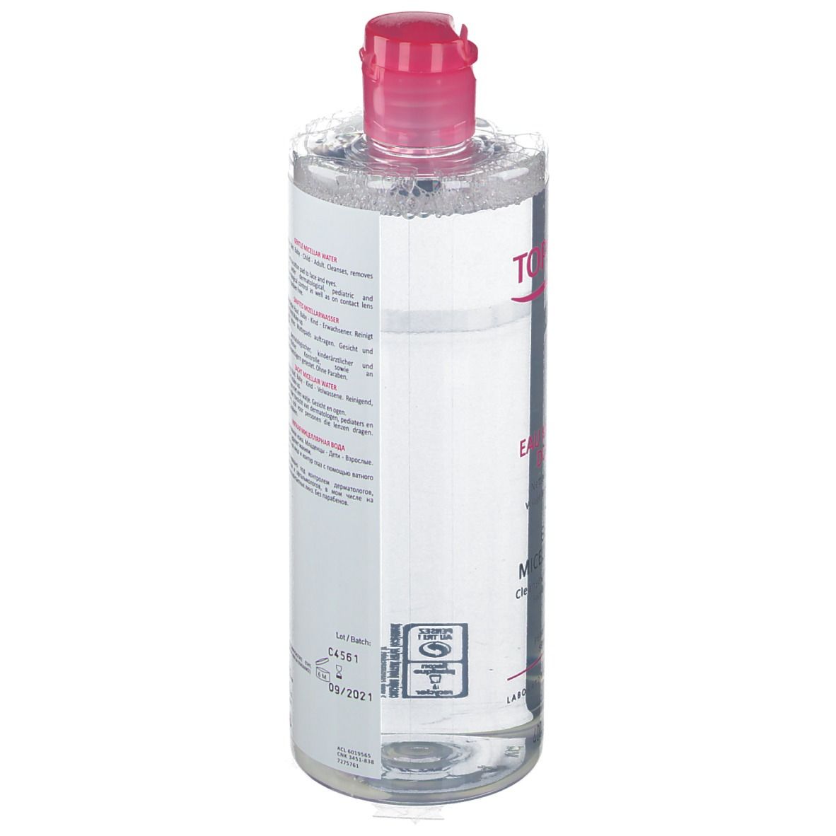 Flacon transparent, bouchon rose. Étiquette avec texte multilingue. Produit pour peaux sensibles.