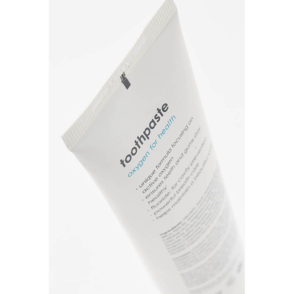 Gros plan sur le tube de dentifrice. Inscription : blue®m, oxygen for health, dentifrice.