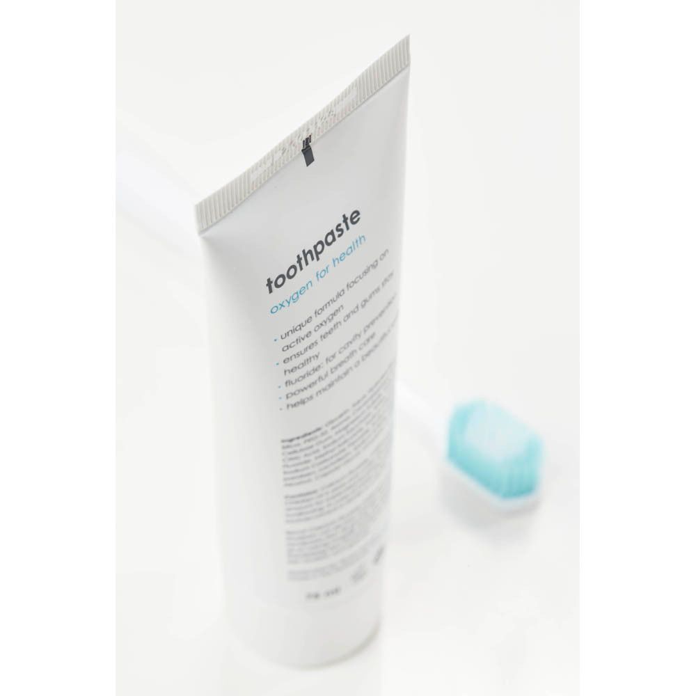 Tube de dentifrice et brosse à dents. Inscription : blue®m, oxygen for health, dentifrice.