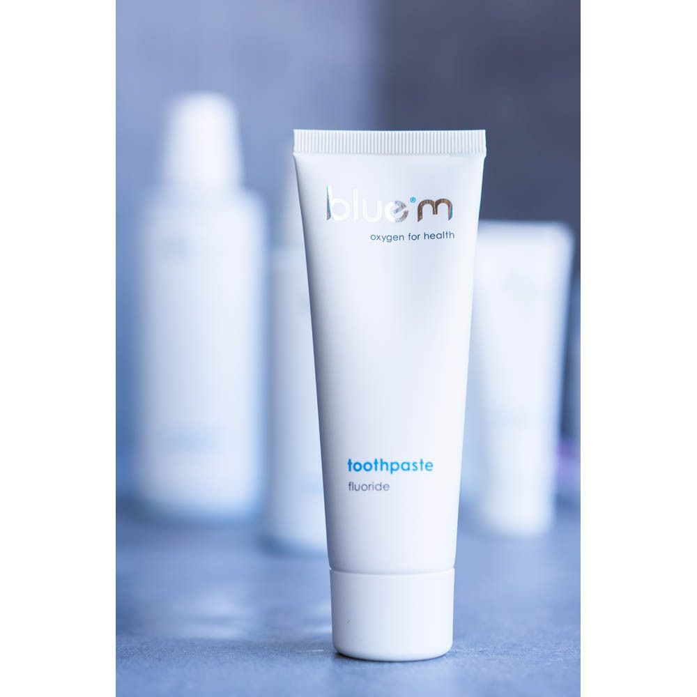 Tube de dentifrice et autres produits. Inscription : blue®m, oxygen for health.