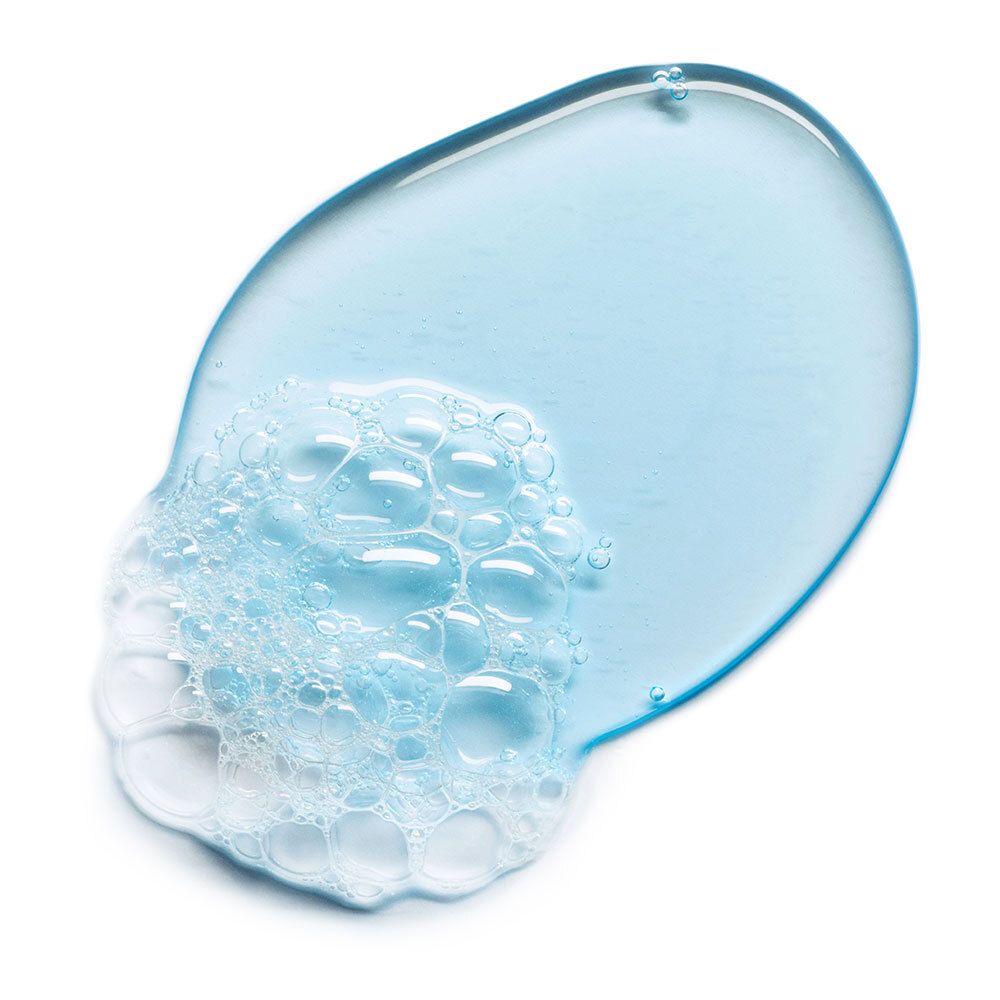 Blauwe gel met schuim op witte achtergrond. Ovale veeg met belletjes.
