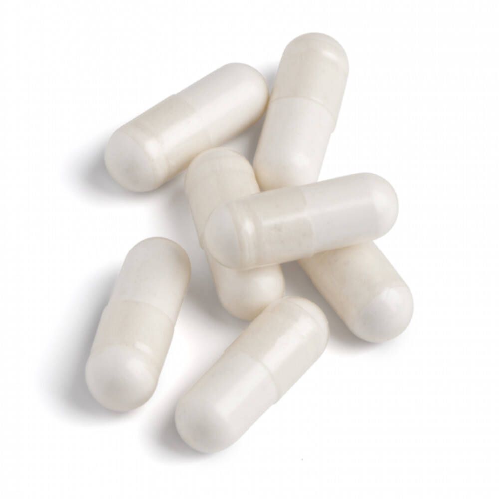 Sept gélules blanches sur fond blanc. Forme de gélule, translucide.