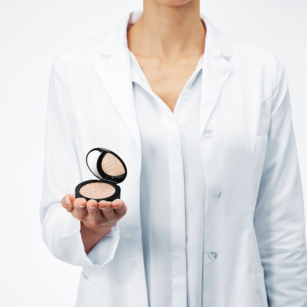Personne tenant une poudre VICHY DERMABLEND Covermatte. La personne porte une blouse blanche.