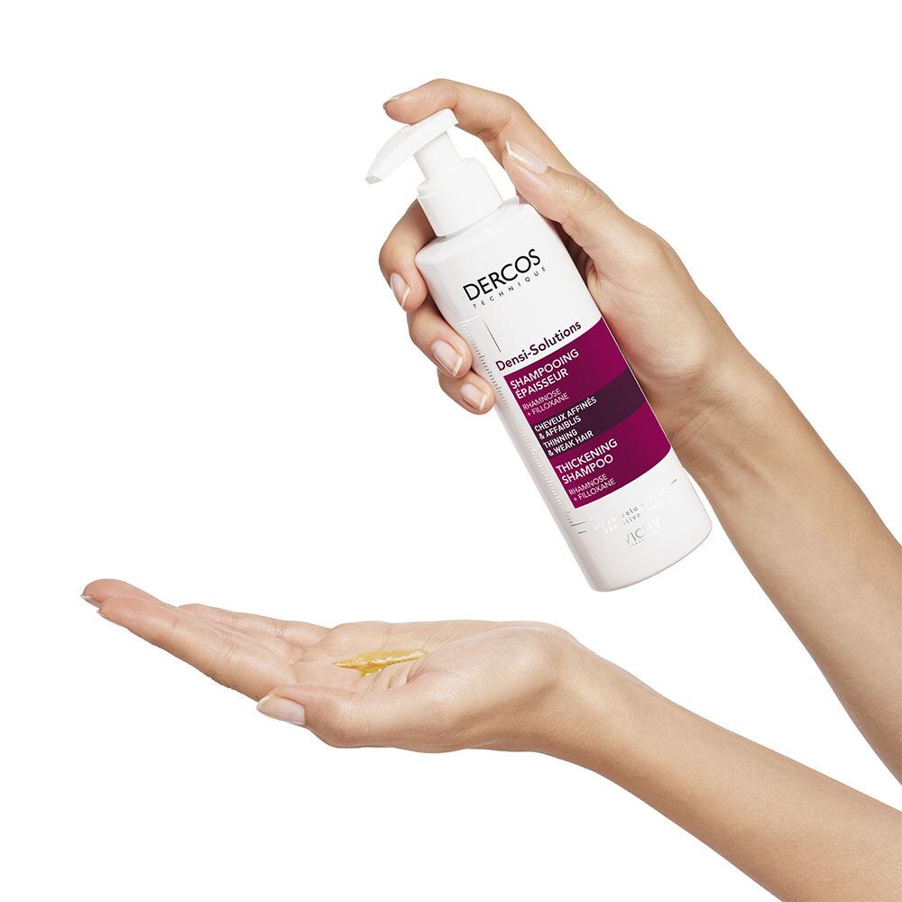 Handen houden een witte shampoo fles. Gele vloeistof op de handpalm. Productnaam zichtbaar.