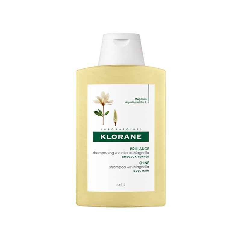 Klorane shampoo met magnolia wax. Gele fles met witte dop. Etiket met productinfo en magnoliabloem.