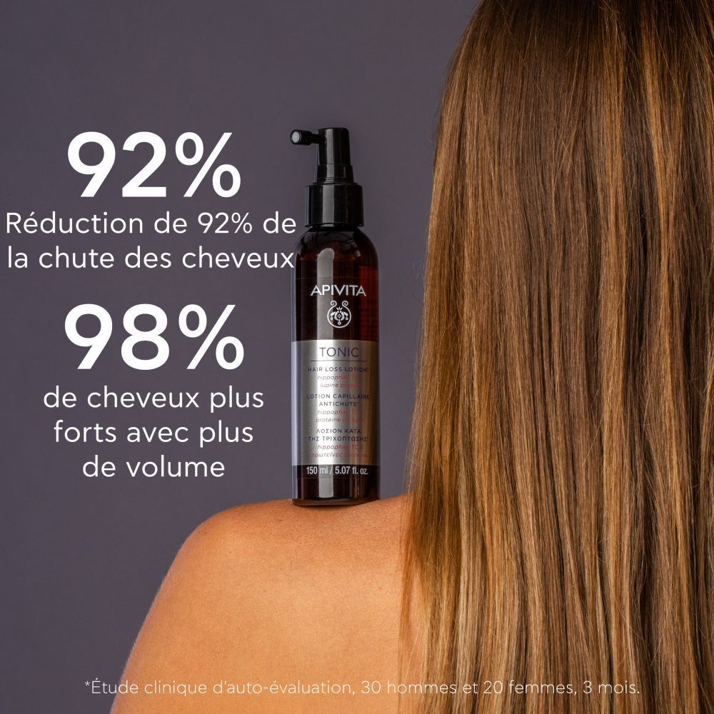 Produit sur l'épaule. Inscriptions: APIVITA, TONIC, Hair Loss Lotion.