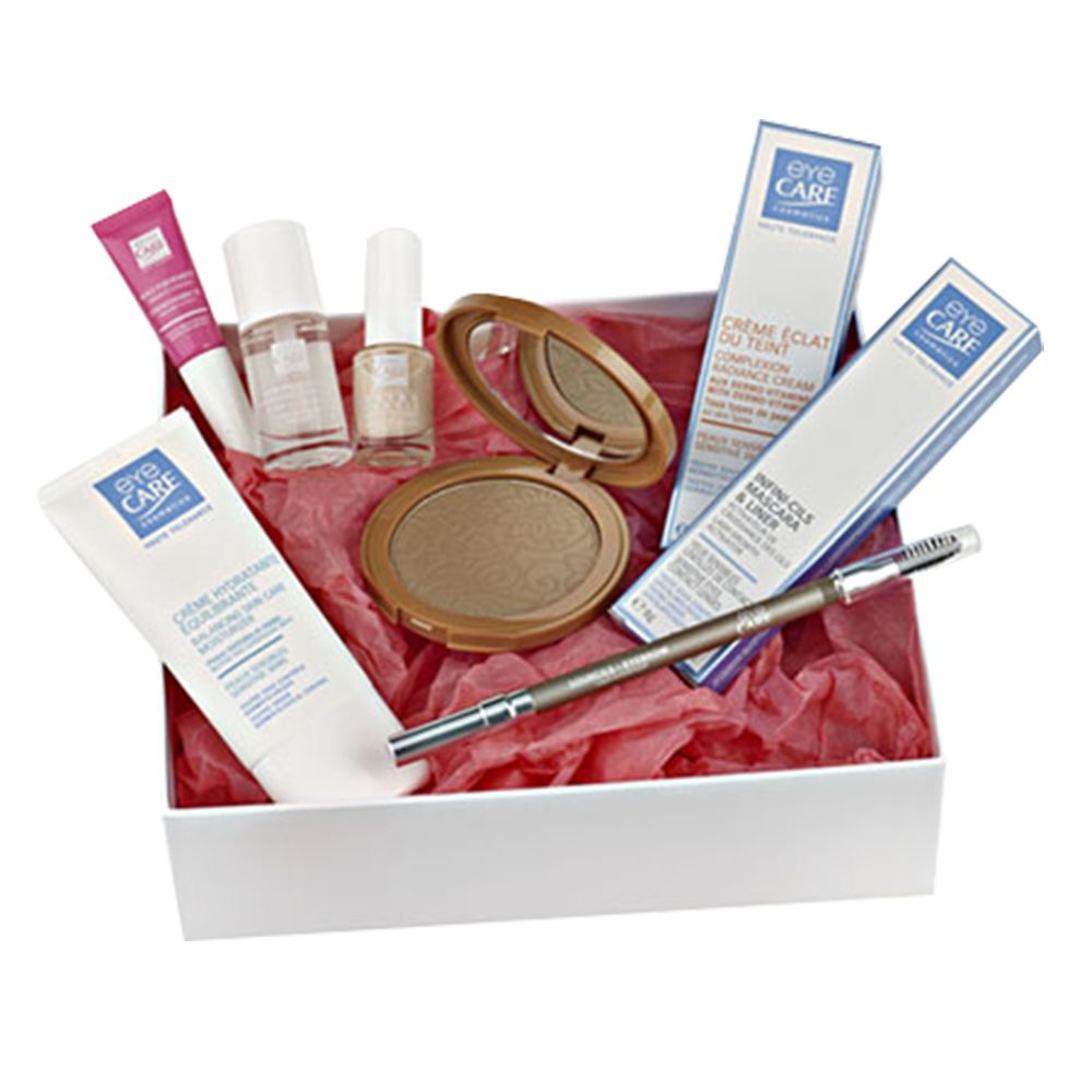 Coffret cosmétique avec produits. Crèmes, vernis à ongles, poudre, mascara et crayon à sourcils. Emballé dans une boîte blanche avec du papier rouge.
