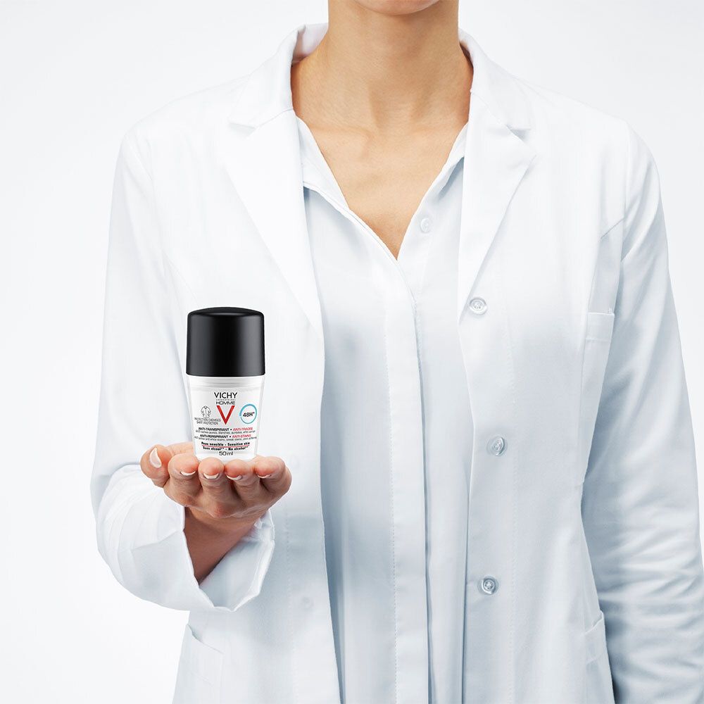 Personne en blouse blanche tenant un roll-on déodorant. Inscription: VICHY HOMME, Anti-transpirant 48h.