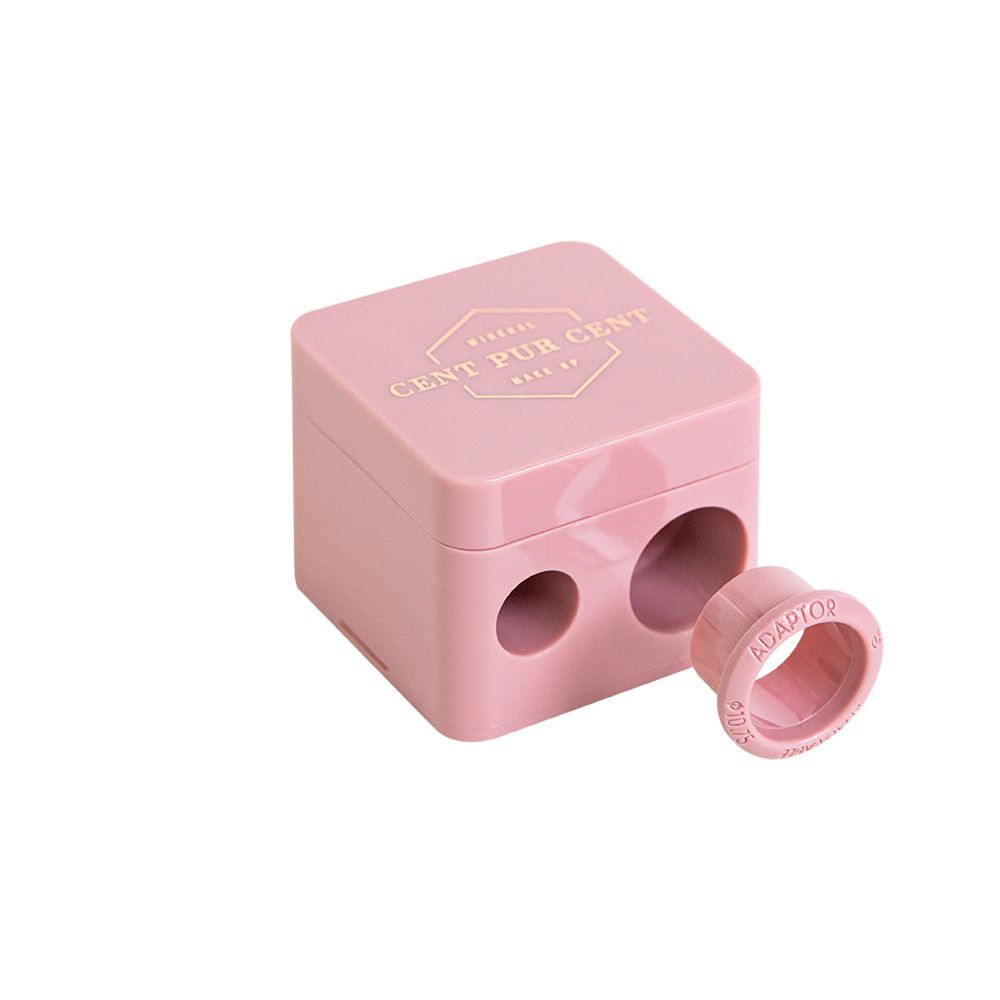 Taille-crayon rose à deux ouvertures. Inscription: Mineral Cent Pur Cent Make Up. Adaptateur à côté.