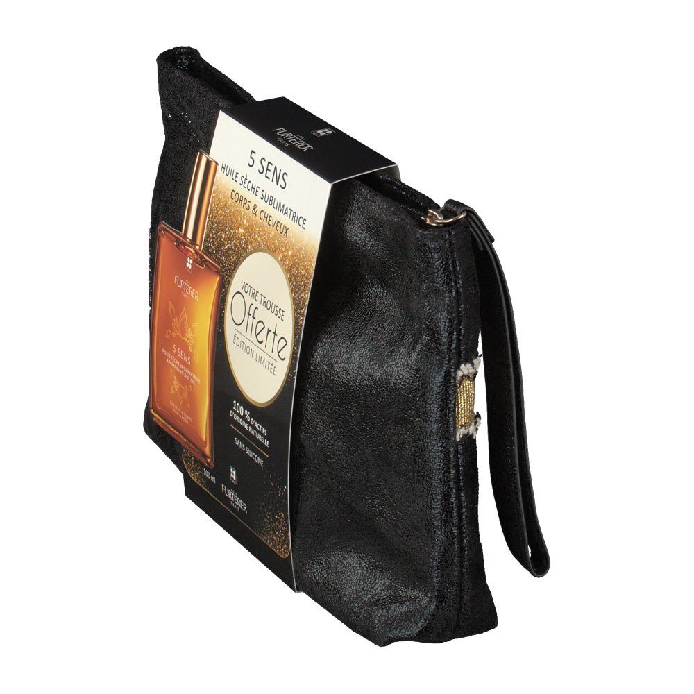 Trousse de toilette noire avec poignée, flacon d'huile sèche et emballage. Flacon avec bouchon doré. Emballage avec nom du produit et texte.