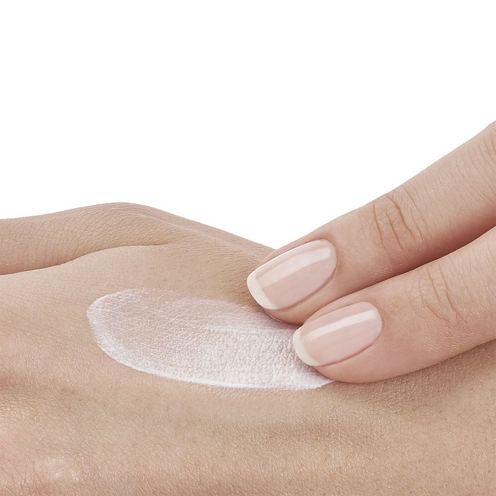 Hand mit Sonnencreme. Weiße Creme auf der Haut. Keine Produktbezeichnung.
