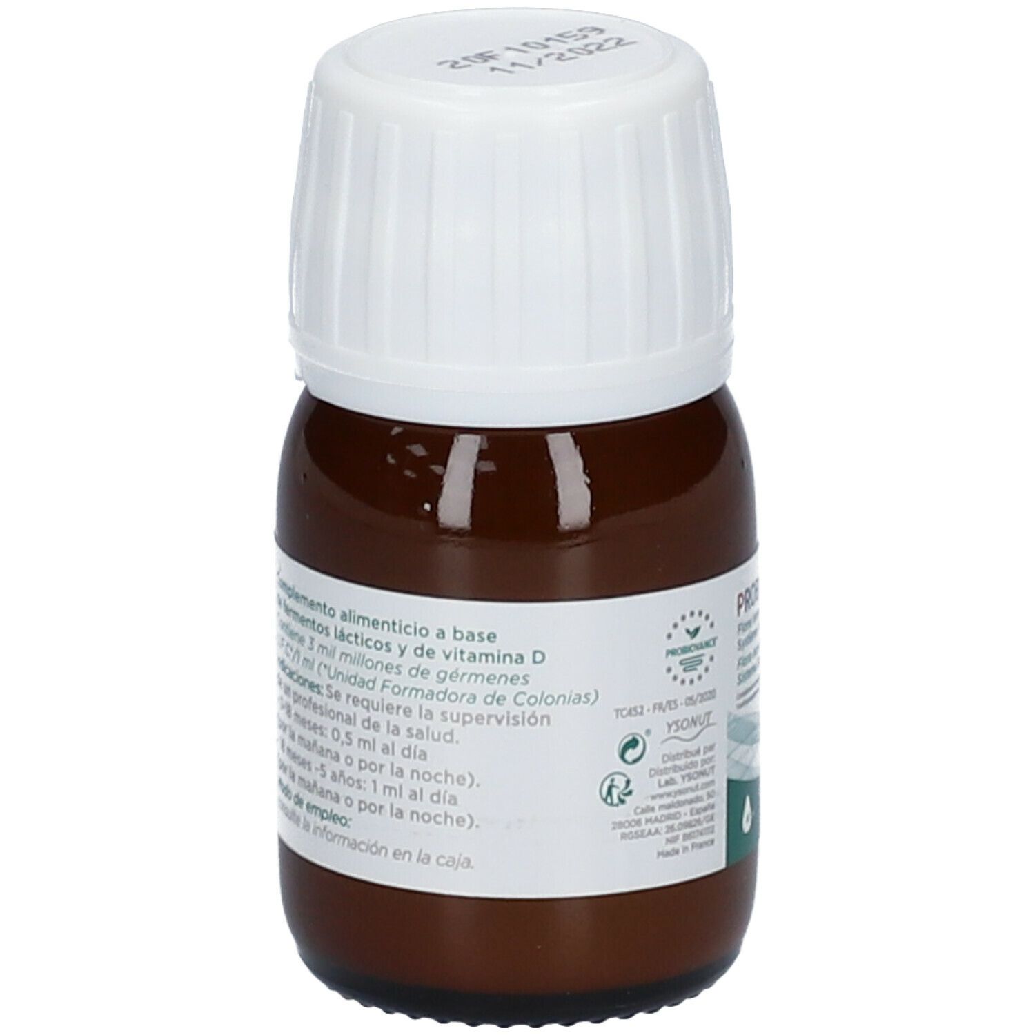 Flacon en verre brun avec bouchon blanc. Étiquette avec informations produit. Contient bactéries lactiques et vitamine D.