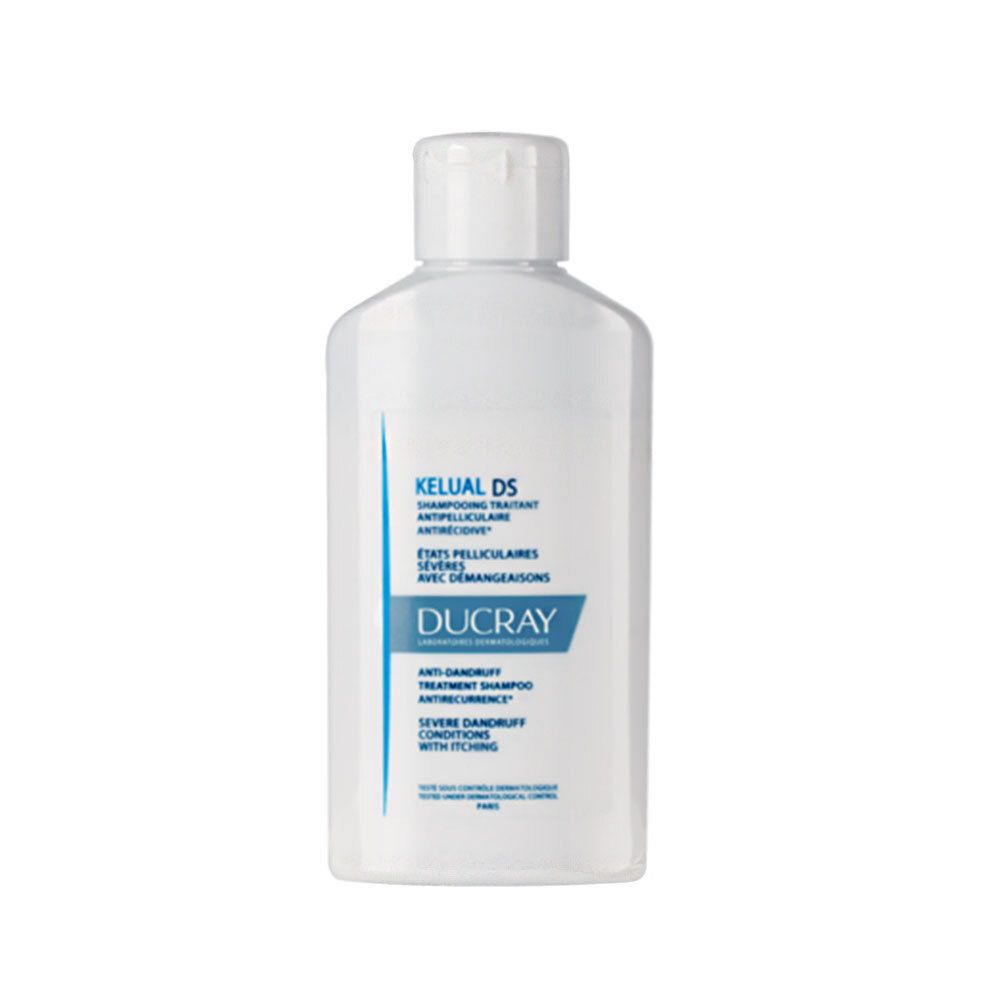 Witte fles met witte dop. Opschrift: Kelual DS, Ducray. Anti-roos shampoo voor ernstige jeuk.